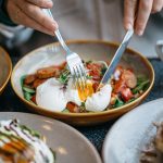 person holding stainless steel fork and knife